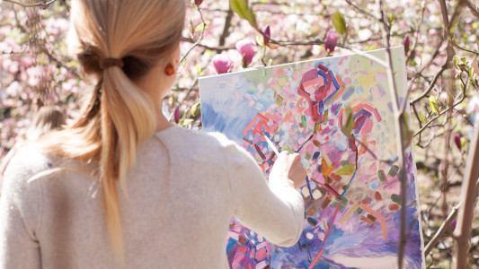 woman painting a picture of flowers