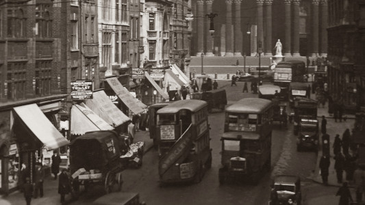 London street in 1920s with buses and cars