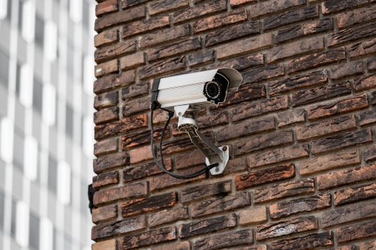 cctv mounted on the corner of a brick building
