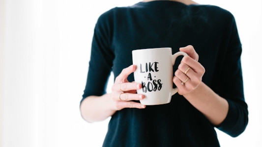 woman holding a mug with the words like a boss printed on it