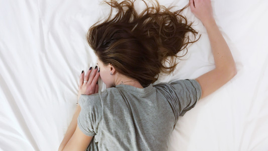 woman lying down sleeping on bed