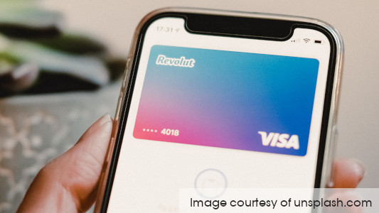 Mobile phone showing the Revolut card image on screen