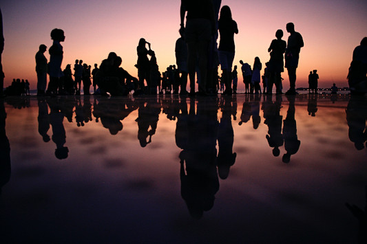 Silhouettes of people on beach in the evening